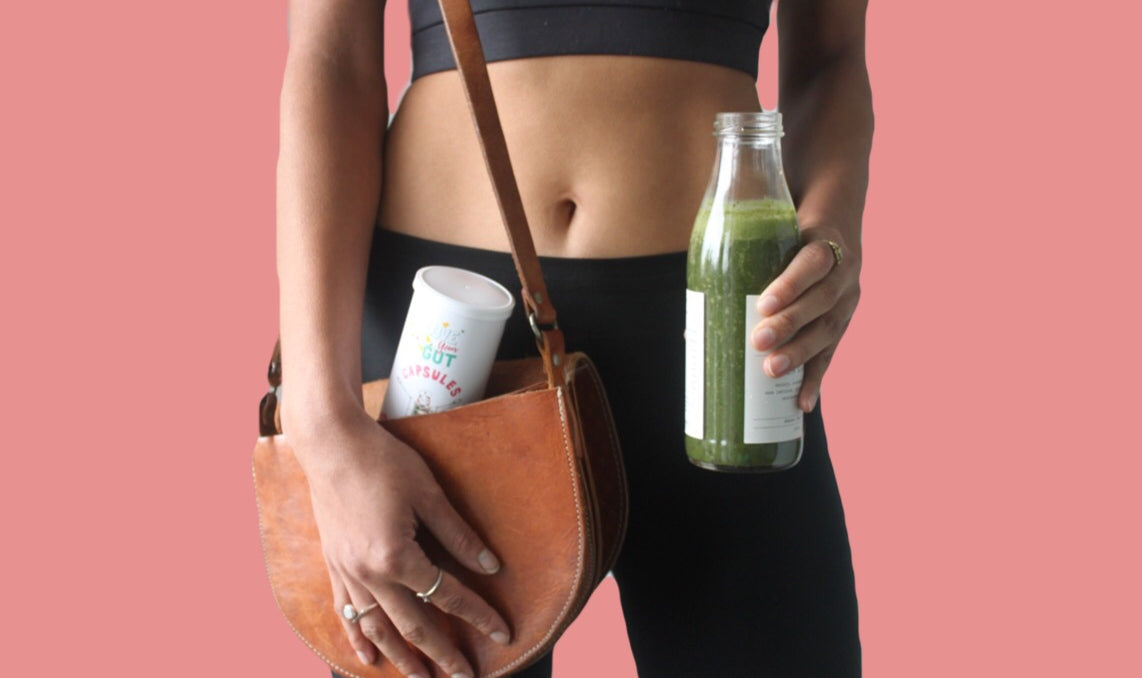 A woman in black leggings holding a bottle of green juice, promoting a healthy lifestyle