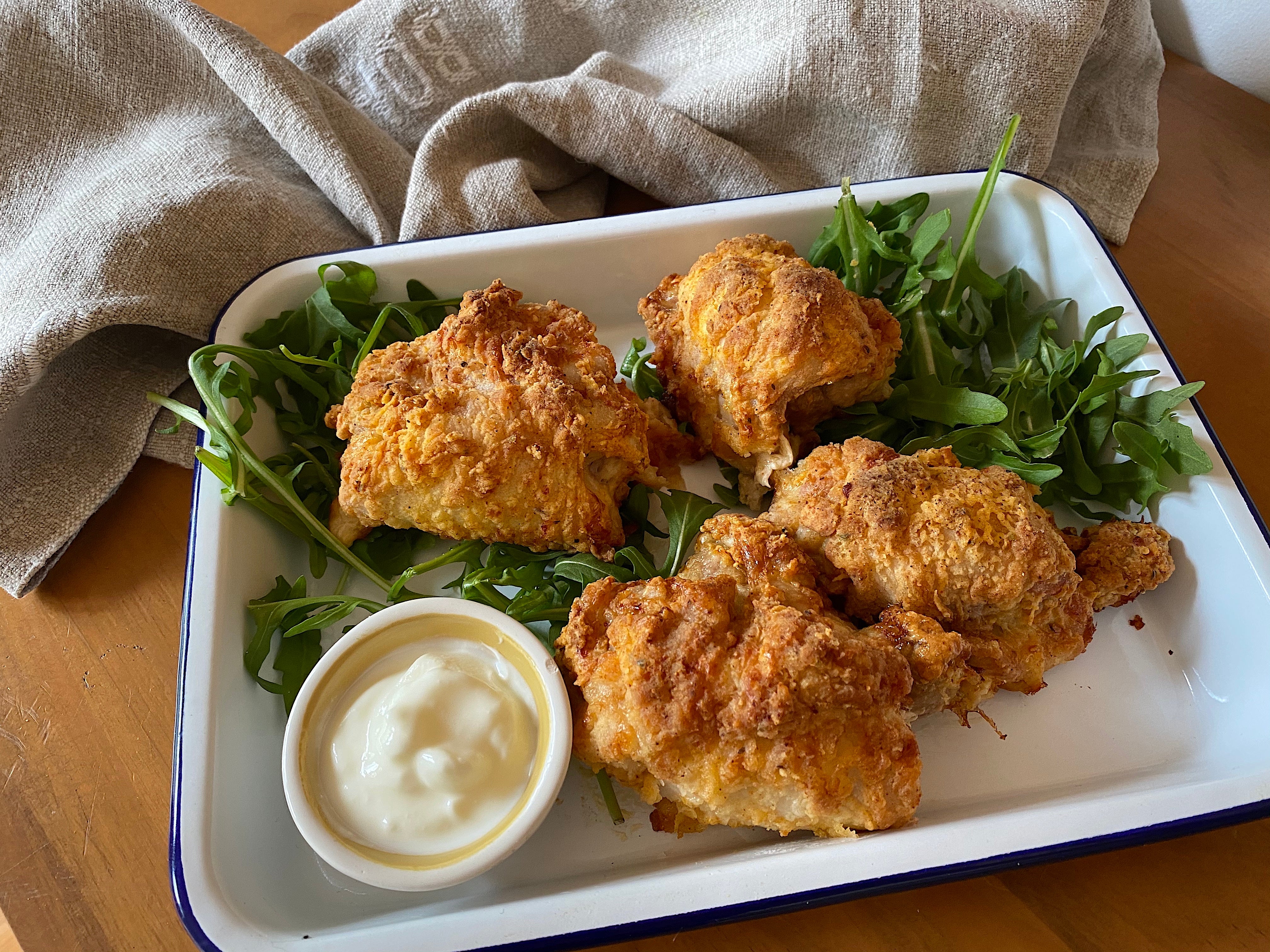 A plate of air fried chicken with a side of greens