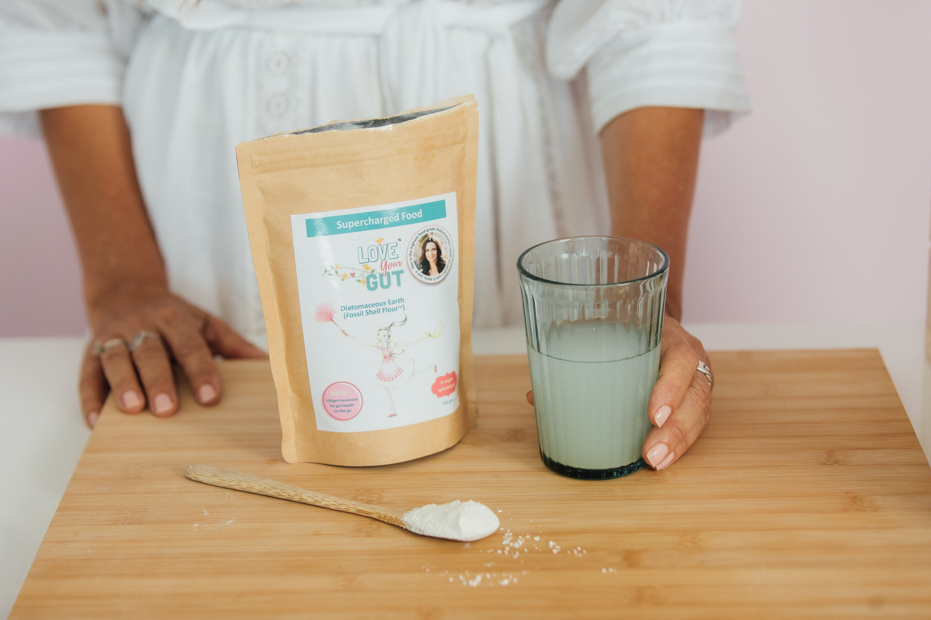 Woman holds glass gut health powder mix for drink