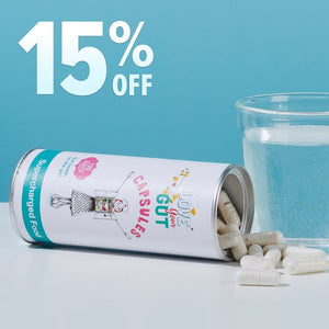 A can of pills next to a glass of water on a table.